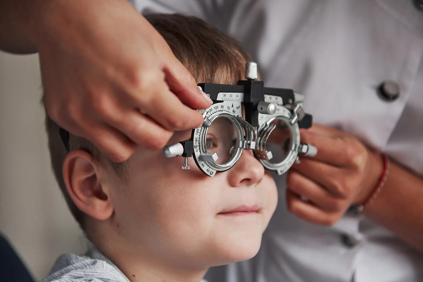 A young boy wearing a trial frame