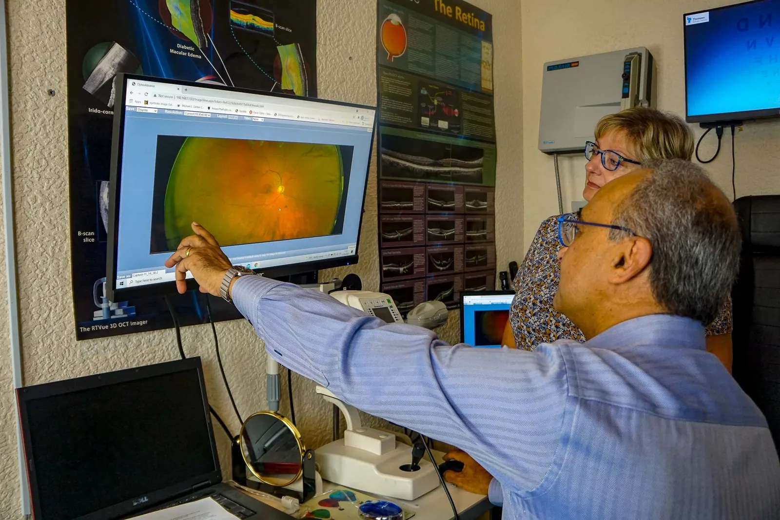 An optometrist explaining a retinal image on screen at Nu-Sight Opticians