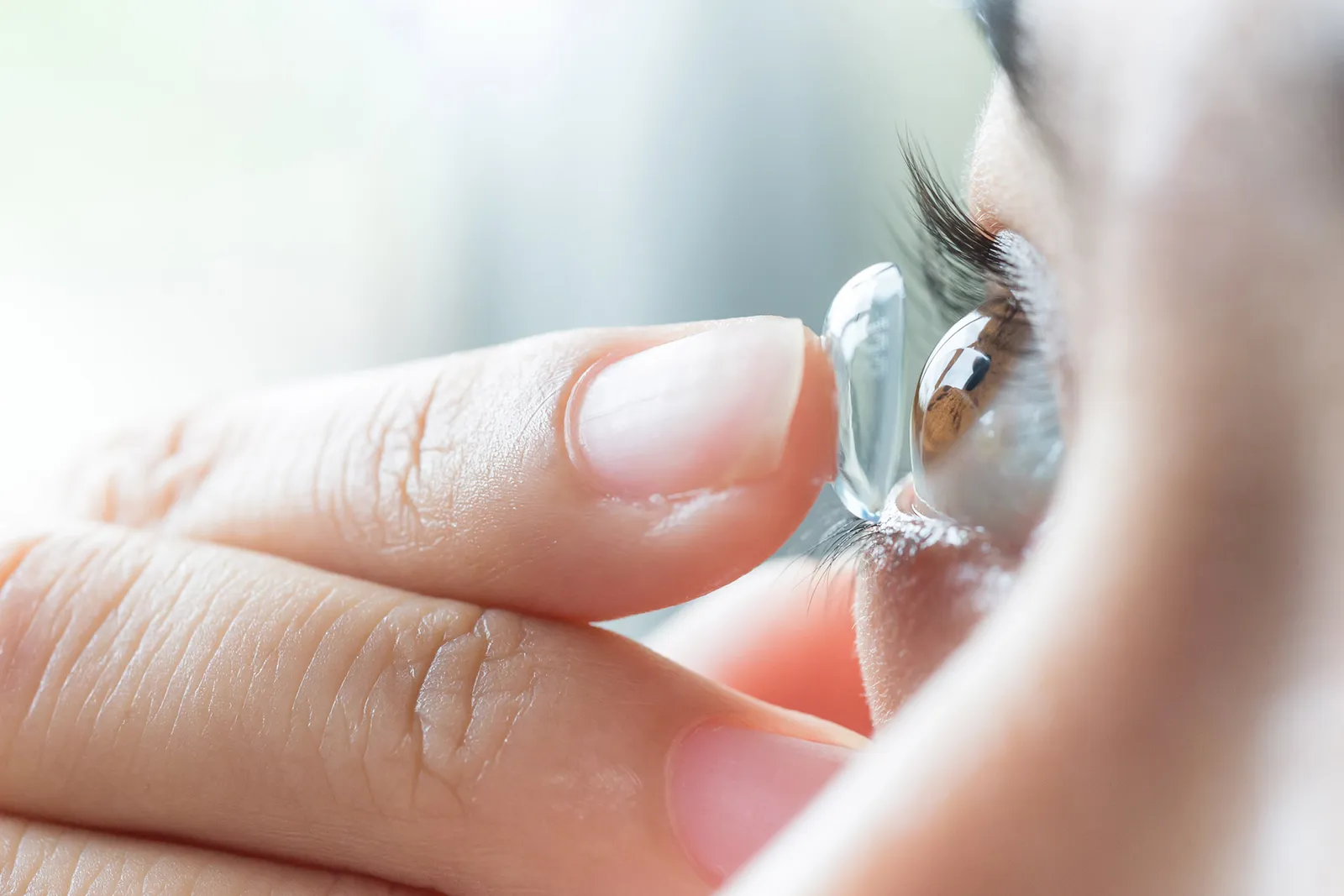 A soft contact lens on a fingertip