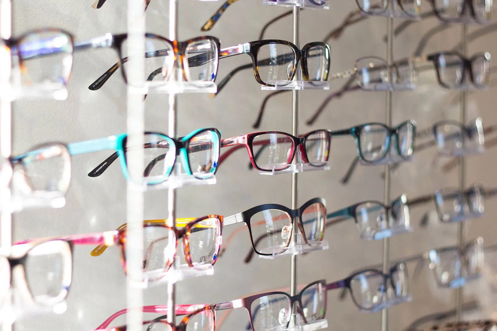 Rows of colourful spectacle frames on an illuminated display wall
